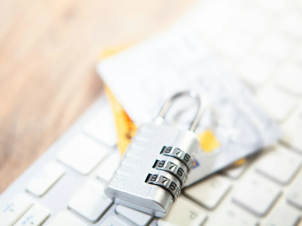 Combination lock beside payment cards and a computer keyboard