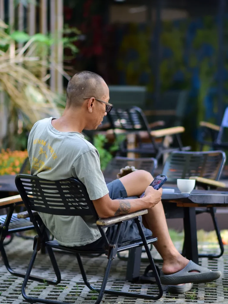 Adult taking a quiet outdoor break with a smartphone and coffee